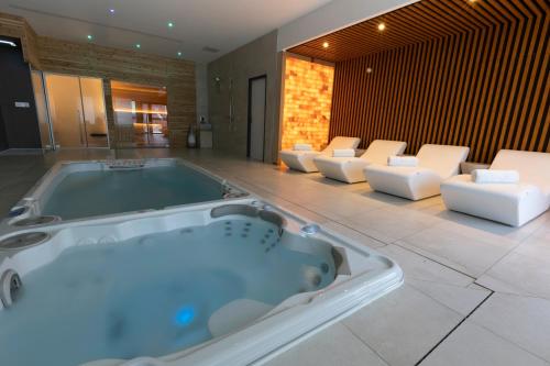 a jacuzzi tub in a room with white chairs at Les Terrasses du Port in Saint-Pierre