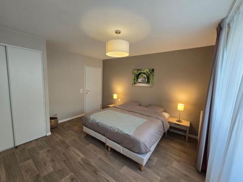 ein Schlafzimmer mit einem Bett, zwei Lampen und einem Fenster in der Unterkunft Résidence services seniors les essentielles Compiègne in Compiègne