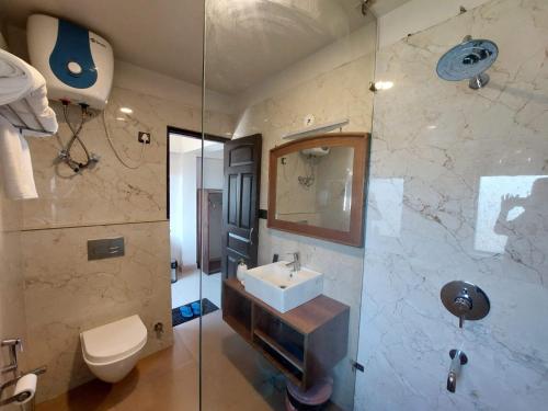 a bathroom with a sink and a toilet and a shower at Alinda House Naukuchiatal by THE GHAUR in Bhīm Tāl