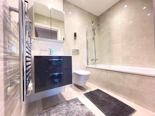 a bathroom with a toilet and a sink and a shower at Urban Living with Free Wi-Fi & Parking in Rickmansworth