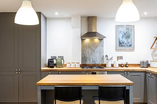 a kitchen with a wooden table and two chairs at Stylish Battersea Home in London