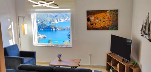 a living room with a window with a view of a lake at Villa Amaryllis in Paleokastritsa