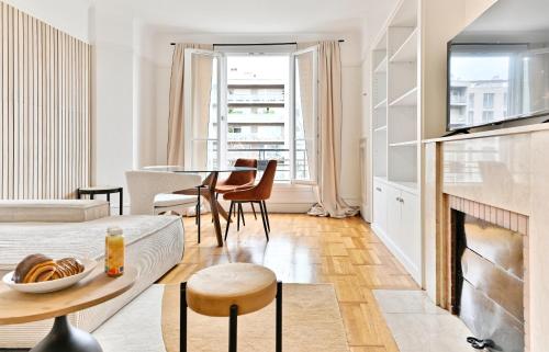 a living room with a fireplace and a table and chairs at Luxurious Flat next Paris - Neuilly - II in Neuilly-sur-Seine