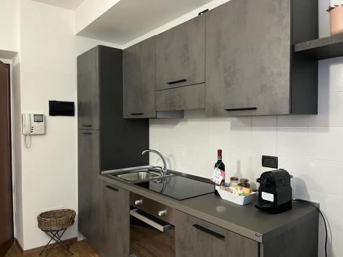 una cocina con fregadero y una botella de vino en Ophelia Leon Charme&Relax, en Bérgamo