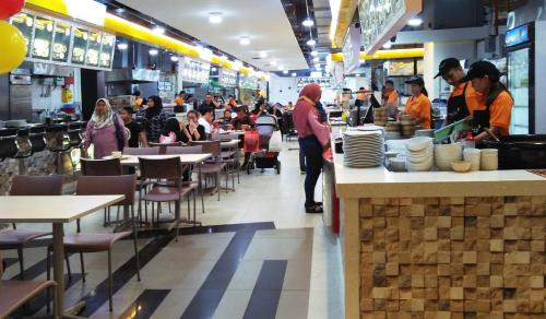 a restaurant with people sitting at tables and a counter at Bintang Lux B&B Suites Times Square KL in Kuala Lumpur