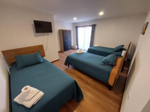 a hotel room with two beds and a television at Hostal La Ruca in Antofagasta