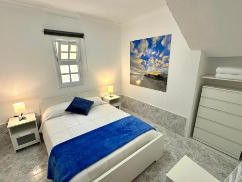 a white bedroom with a bed and a window at Santa Úrsula 21 in Costa Calma