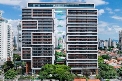 um edifício alto com guarda-chuvas em frente a uma cidade em Habitarte - Studio Luxo Brooklin em São Paulo