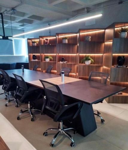 a conference room with a large wooden table and chairs at Stúdio, piscina, bicicleta, churrasqueira, restaurante, espaço gourmet, ar central in Maceió