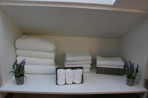 a pile of towels on a shelf in a bathroom at La Parada del Camino Apartamento in Negreira