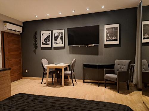 una camera con tavolo, sedie e televisore di Apartmani Kameno Sidro a Bilice (Bilizze)