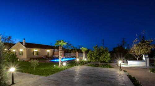 a house with a courtyard at night with lights at Rhodian Gaea Villa in Theologos