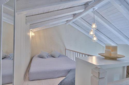 a white bedroom with a bed and a table at Rhodian Gaea Villa in Theologos