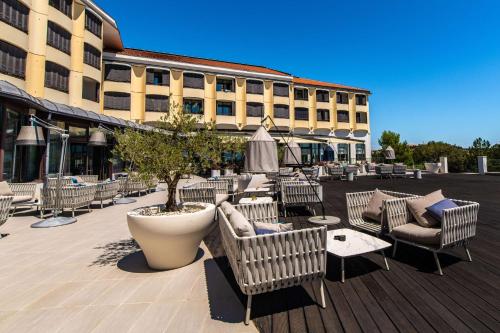 a patio with chairs and tables and a building at Park Plaza Histria Pula in Pula
