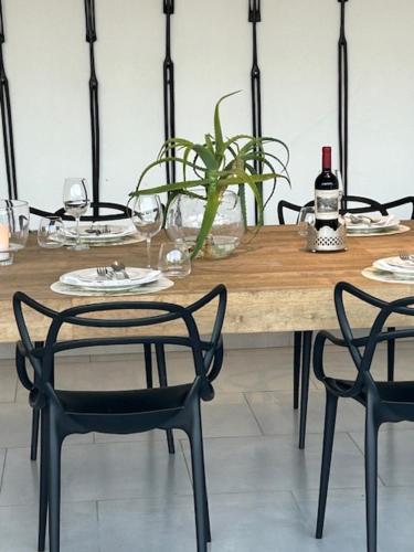 a wooden table with two chairs and a bottle of wine at St Francis Golf Lodge in St Francis Bay
