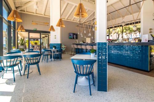 a restaurant with blue tables and chairs and a bar at Park Plaza Histria Pula in Pula