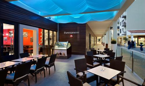 a restaurant with tables and chairs and a television at Park Plaza Histria Pula in Pula