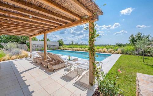 an outdoor patio with a pool and a pergola at Charlotta in Radovani