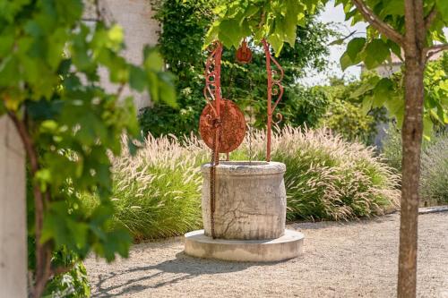 a birdbath in a garden with a tree at Charlotta in Radovani