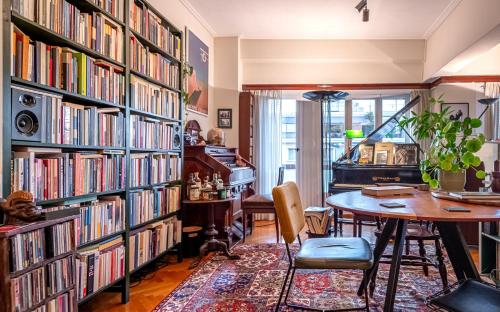 a room with a table and bookshelves filled with books at Chic 2BR Bright Penthouse with Open Wood Staircase in Athens