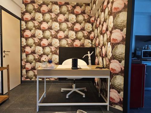 - un bureau dans une chambre avec un mur floral dans l'établissement Au Pied Du Château, à Bouillon