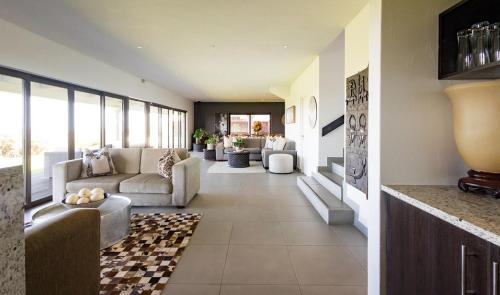 a living room with couches and chairs in a house at St Francis Golf Lodge in St Francis Bay