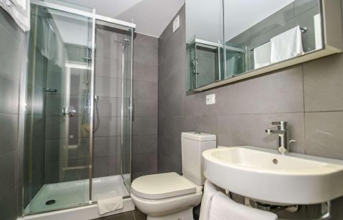 a bathroom with a toilet and a sink and a shower at Park Plaza Verudela Pula in Pula