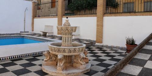 une fontaine au milieu d'une cour avec une piscine dans l'établissement casa el chiquitín, à La Zubia