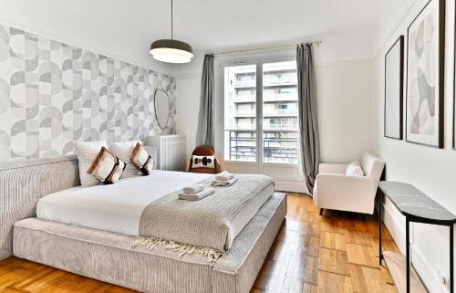Un dormitorio con una cama grande y una ventana. en Luxurious Flat next Paris - Neuilly, en Neuilly-sur-Seine