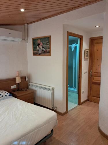 a bedroom with a bed and a door to a hallway at EVA & TRAVEL - CAL MARCEL - Habitacion in Prades