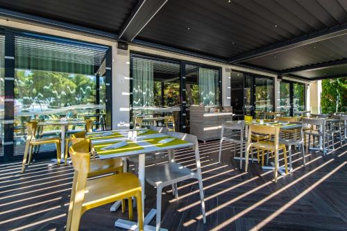 a restaurant with tables and chairs on a deck at Park Plaza Arena Pula in Pula