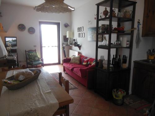 カステル・ディ・サングロにあるVilla Villacolle d'Eliaのリビングルーム(赤いソファ、テーブル付)