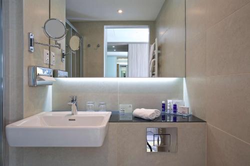 a bathroom with a sink and a mirror at Park Plaza Arena Pula in Pula