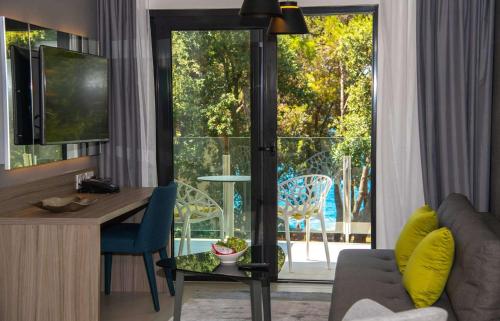 a living room with a desk and a view of a balcony at Park Plaza Arena Pula in Pula