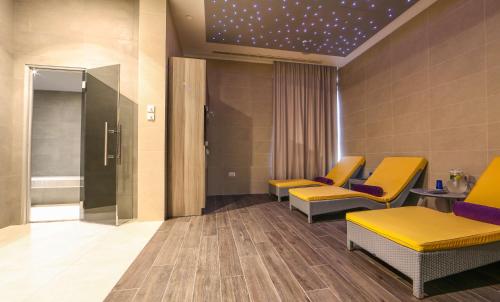 a waiting room with yellow chairs and a star ceiling at Park Plaza Arena Pula in Pula