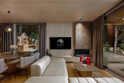 a living room with a white couch and a table at Villa Luiv Chalet in Mrkopalj