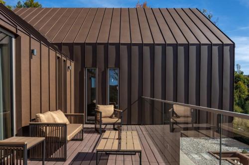 a building with a roof with chairs on a deck at Villa Luiv Chalet in Mrkopalj