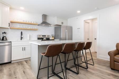 Una cocina con encimera y taburetes. en Ocean Lofts in the Vibe #5 - 5 min walk to beach, en Virginia Beach