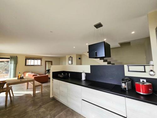 a kitchen with a counter top and a living room at Belle villa avec piscine et vue mer- Hauteurs de Bastia in Bastia