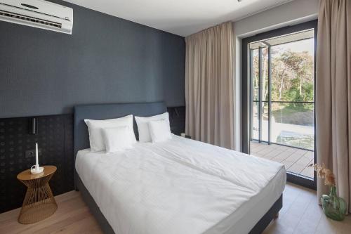 a bedroom with a large bed and a large window at Apartamenty na Półwyspie Wydma&Las in Jastarnia