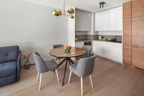 a kitchen and dining room with a table and chairs at Apartamenty na Półwyspie Wydma&Las in Jastarnia