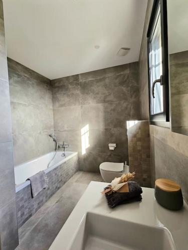 une salle de bain avec une baignoire, des toilettes et un lavabo dans l'établissement Belle villa avec piscine et vue mer- Hauteurs de Bastia, à Bastia