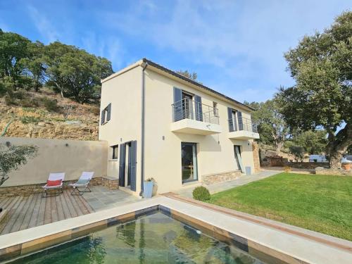 une maison avec une piscine devant une maison dans l'établissement Belle villa avec piscine et vue mer- Hauteurs de Bastia, à Bastia