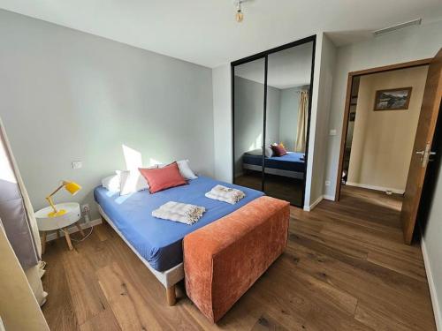 une chambre avec un lit bleu et un miroir dans l'établissement Belle villa avec piscine et vue mer- Hauteurs de Bastia, à Bastia