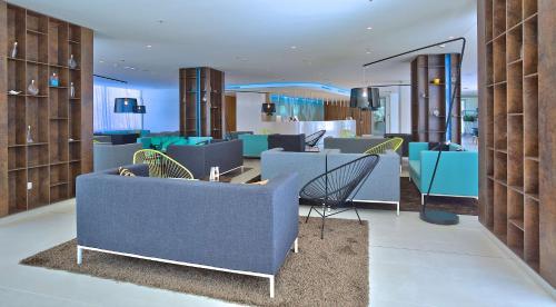 een lobby met een blauwe bank en stoelen bij Park Plaza Belvedere Medulin in Medulin