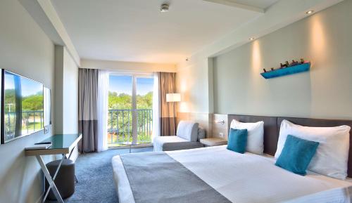 a hotel room with a large bed and a chair at Park Plaza Belvedere Medulin in Medulin
