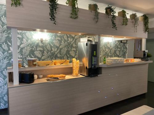 a kitchen with a counter with a microwave and food at H&ocirc;tel Bagatelle in Pont-&agrave;-Mousson