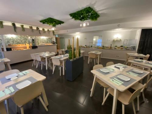 a restaurant with tables and chairs and a counter at H&ocirc;tel Bagatelle in Pont-&agrave;-Mousson