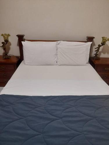 um quarto com uma cama grande com lençóis e almofadas azuis em Prince Apart vista P. Canto em Vitória