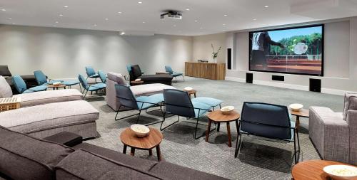 a living room with couches and chairs and a projection screen at Park Plaza Belvedere Medulin in Medulin